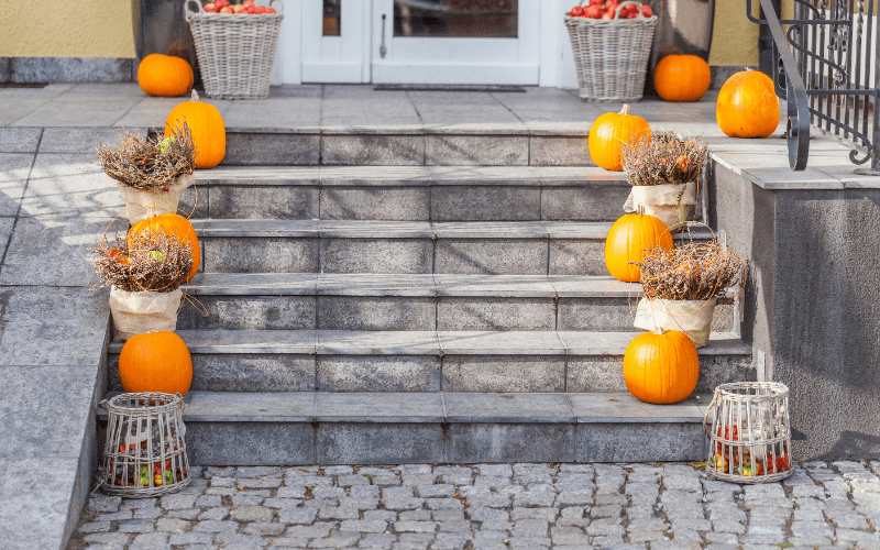 curb appeal exterior of home in fall - pumpkins on stairs