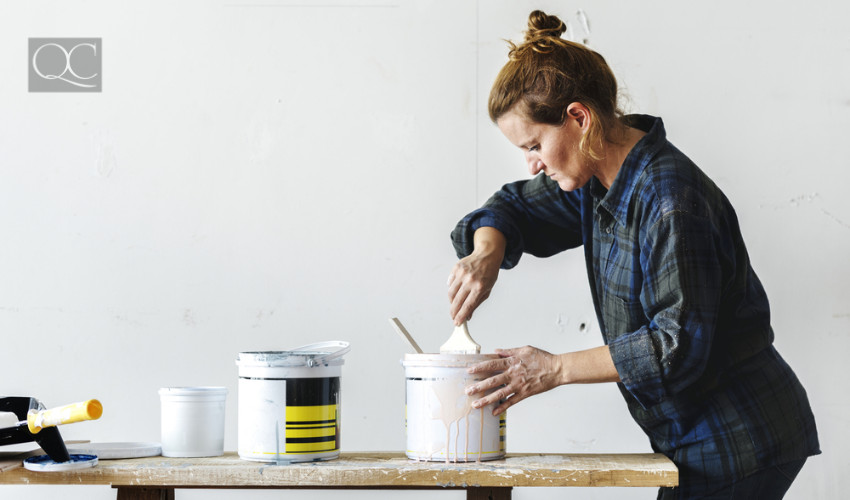 creative interior decorator getting her hands dirty with painting