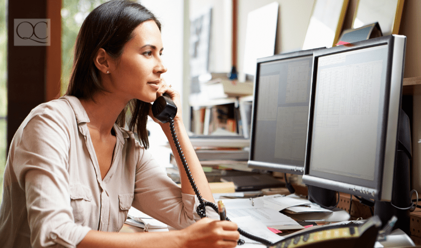 professional woman working on computer and speaking on the phone