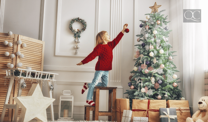 child decorating christmas tree at home