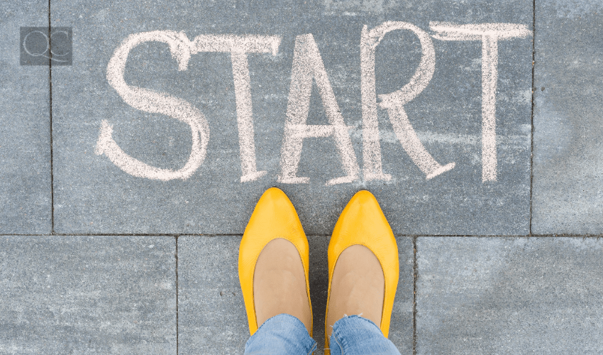 woman's feet on concrete with "START" written above them in chalk