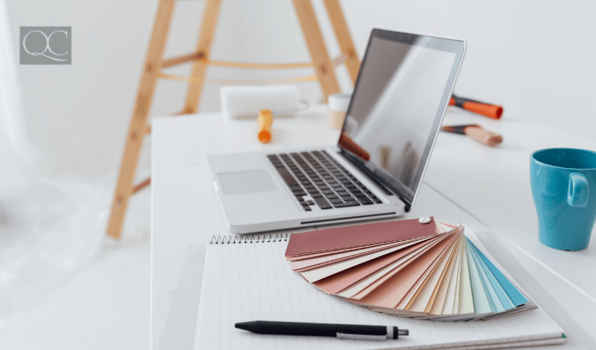 Laptop and color swatches on table, home renovations in background