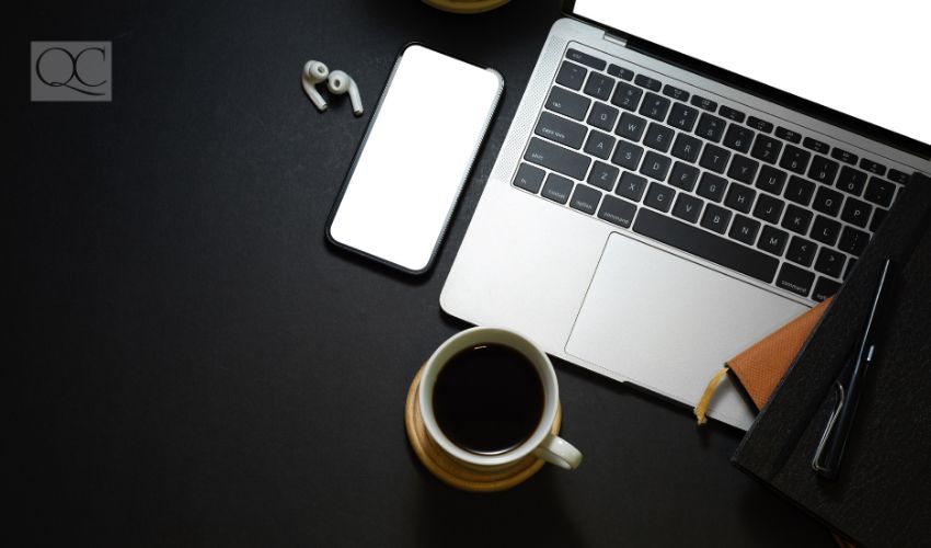 Top view of dark workspace with laptop, smartphone, coffee cup, stationery and copy space, clipping path