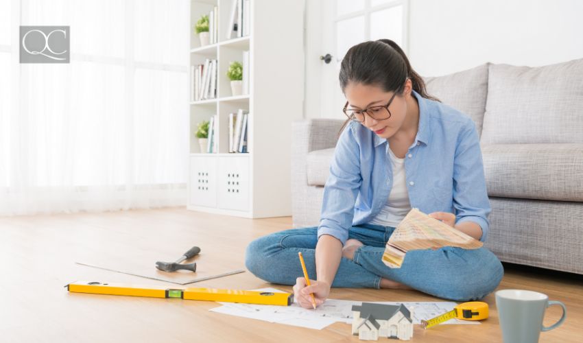 Feng Shui consultant sitting in living room wooden floor using palette tool choosing color for design house interior.