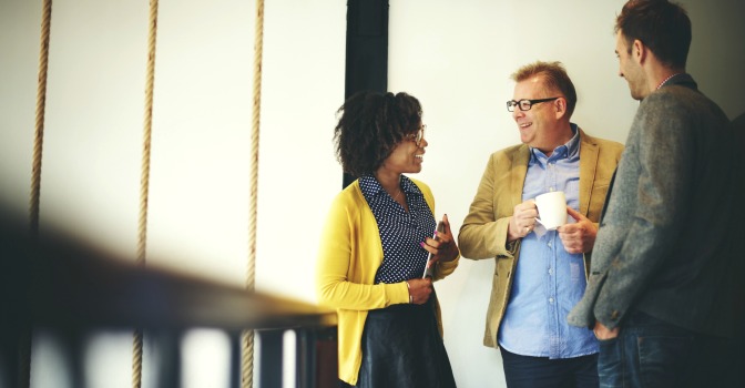 Three business people talking together at a conference