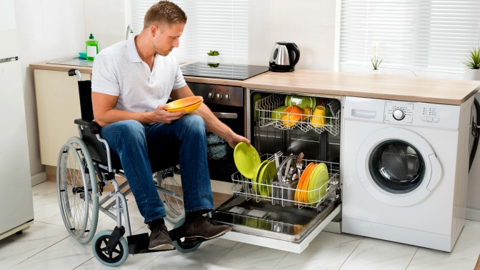 Man in wheelchair loads dishwasher