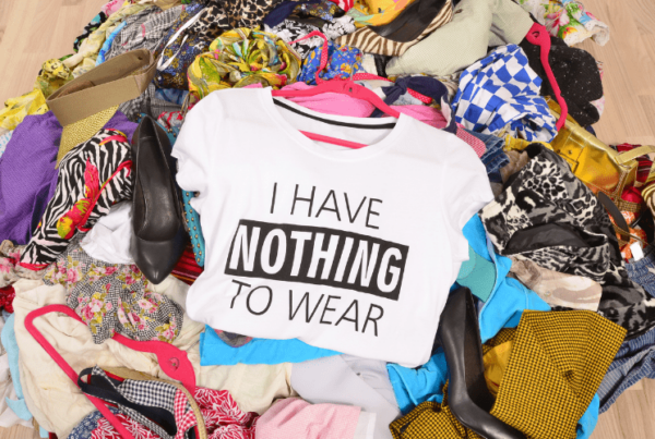 messy pile of clothes and shoes on floor, with shirt on top that reads "i have nothing to wear"