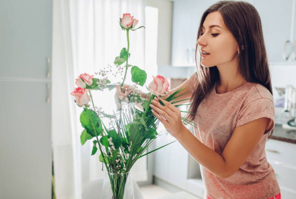 woman interior decorating - arranging flowers in vase