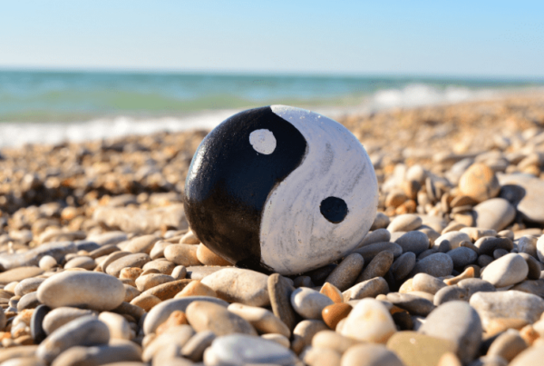 Feng Shui yin and yang symbol painted on rock on rocky beach