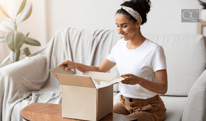 woman opening package at home in living room