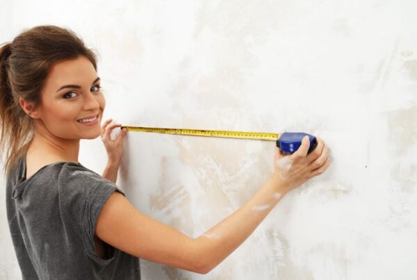 How to become an interior decorator measuring for beginners Feature Image, woman measuring wall with measuring tape