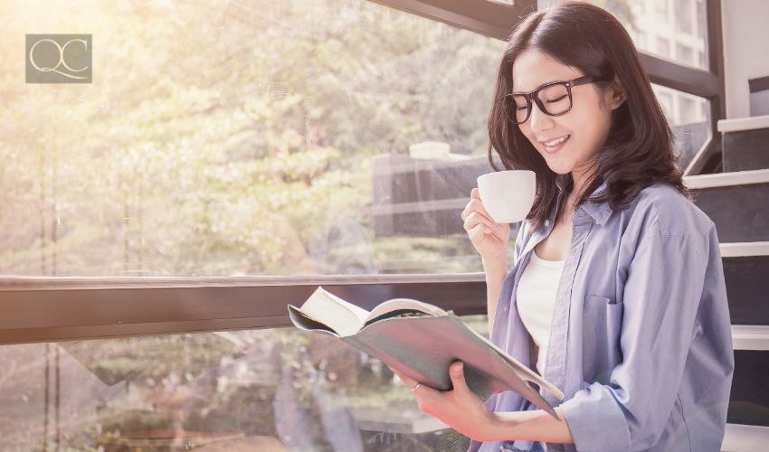 Woman drinking coffee and reading textbook