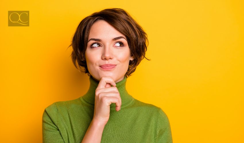 Adult woman thinking with a smile in front of yellow background