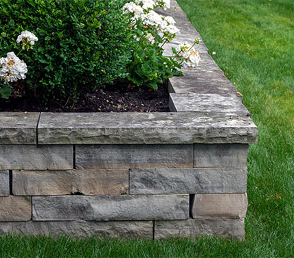 Stone hardscape surrounding garden bed