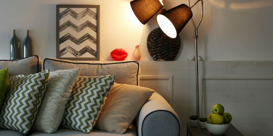 Beautiful modern living room with grey sofa and floor lamp. Home stager article.