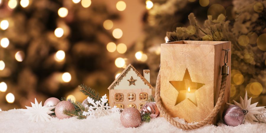 Composition with wooden Christmas lantern on table. Bokeh effect. Holiday decorating article.