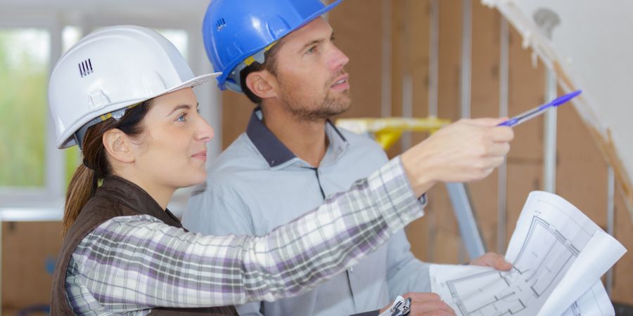 female architect and coleague visiting large construction site. Designers working with contractors article.